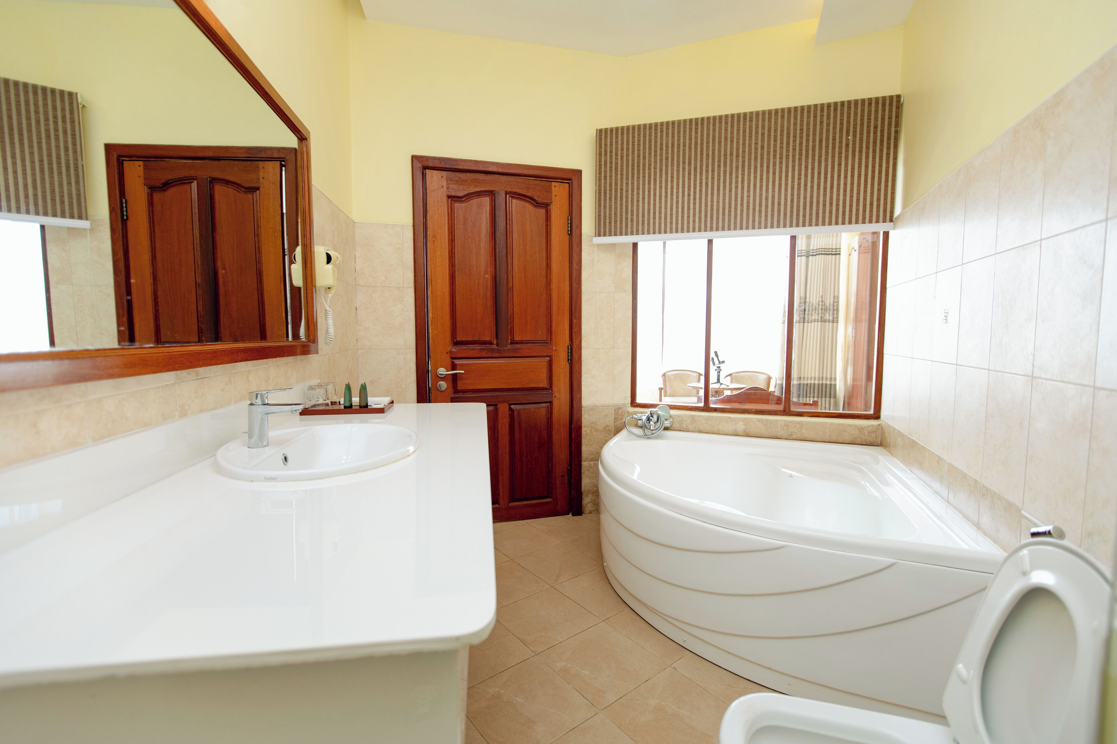 Un baño con lavamanos doble, bañera y espejo.