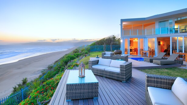A beachfront property with a deck, outdoor seating, and a pool. - Dune Villa Wilderness (Wilderness)