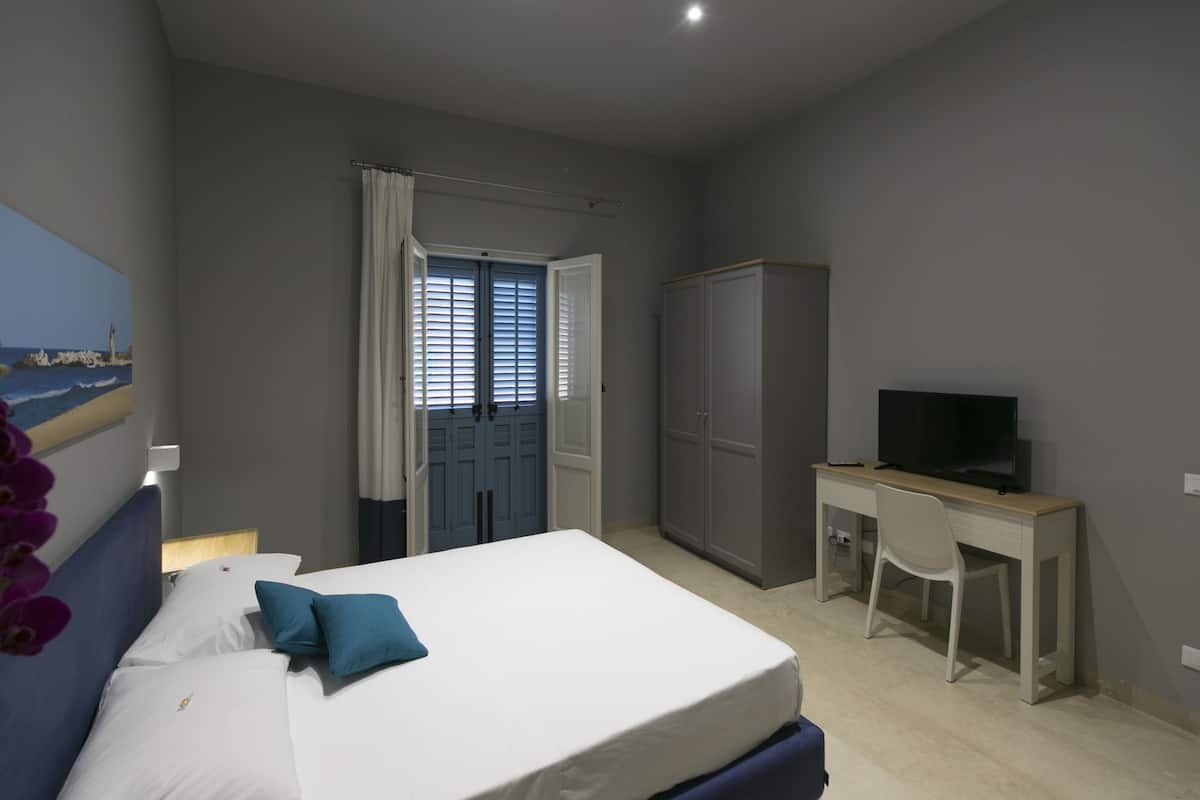 Ein Schlafzimmer mit einem Bett, einem Schreibtisch, einem Fernseher und einem Kleiderschrank.