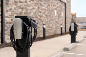 Electric vehicle charging stations mounted on a wall with a stone facade.