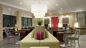 A modern lounge area with a sofa, chairs, and a dining table. - Home2 Suites by Hilton Leavenworth Downtown (Leavenworth)