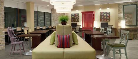 A modern lounge area with a sofa, chairs, and a dining table.