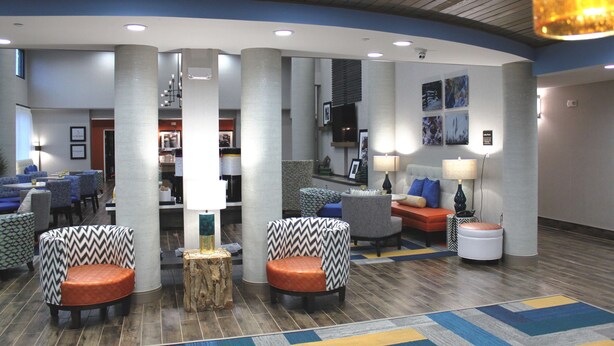 A lobby with a curved ceiling, multiple seating areas, and a central column.
