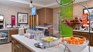 Una mesa de buffet con diversos alimentos y una estación de bebidas.