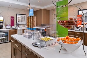 A buffet setup with various food items and a beverage station. - Hampton Inn & Suites St. Paul Oakdale/Woodbury (Oakdale)