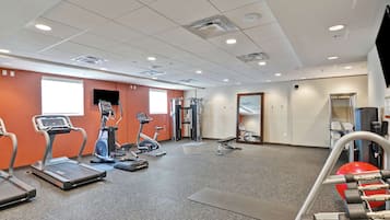 A gym with treadmills, elliptical machines, and weightlifting equipment.