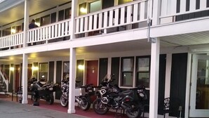 A motel with a two-story balcony, several motorcycles parked outside, and a red carpet entrance. - Briarwood Motor Inn (Lincoln)