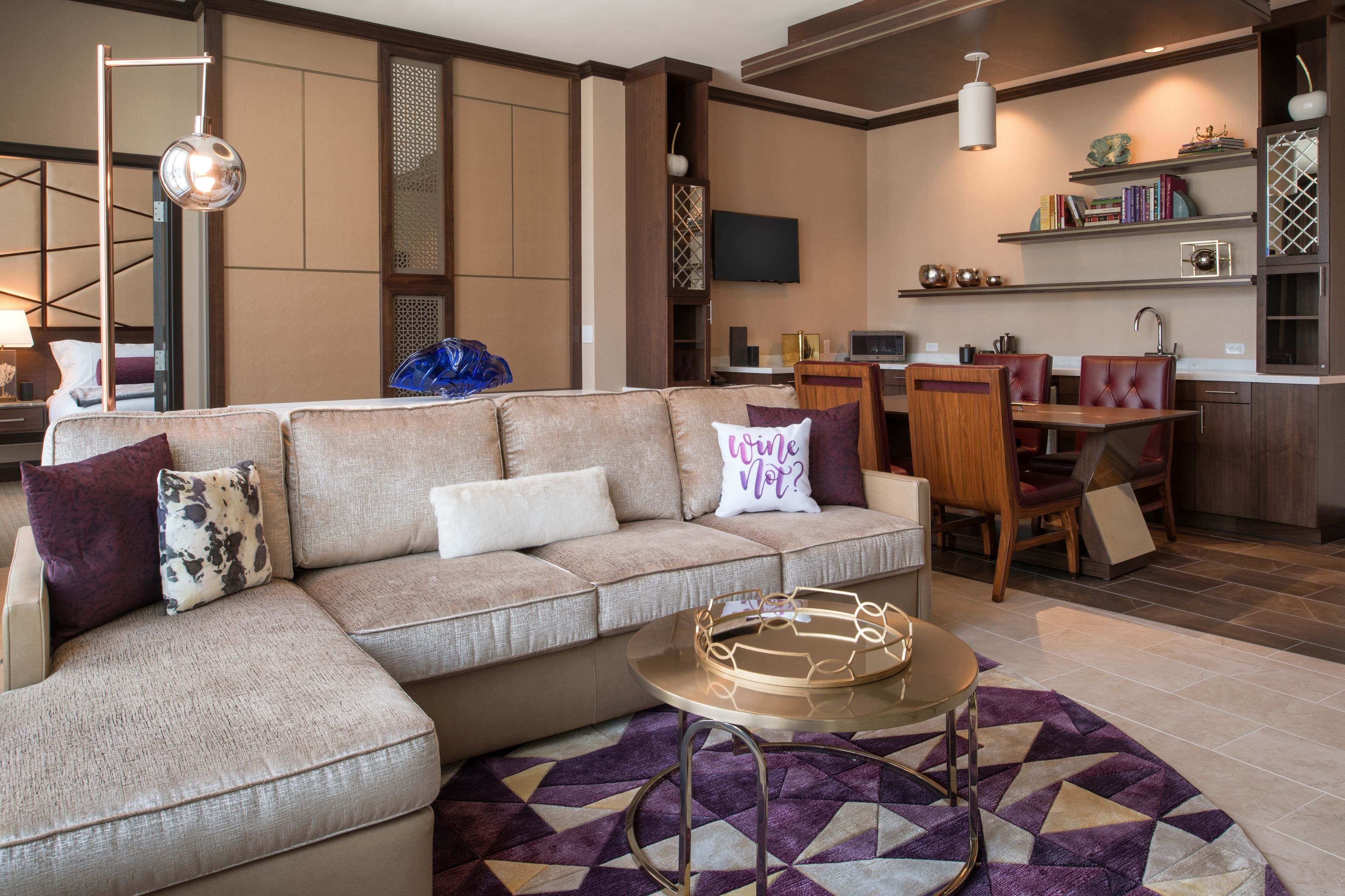 Una sala de estar moderna con un sofá seccional, una mesa de centro y un comedor con mesa y sillas.