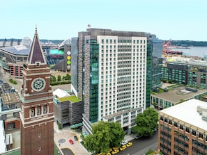 A high-rise building with a clock tower, surrounded by other modern buildings and a river. - Embassy Suites by Hilton Seattle Downtown Pioneer Square (Seattle)