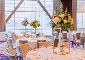 A banquet hall with round tables set for dining, each with a gold centerpiece and glassware. - Embassy Suites by Hilton Seattle Downtown Pioneer Square (Seattle)