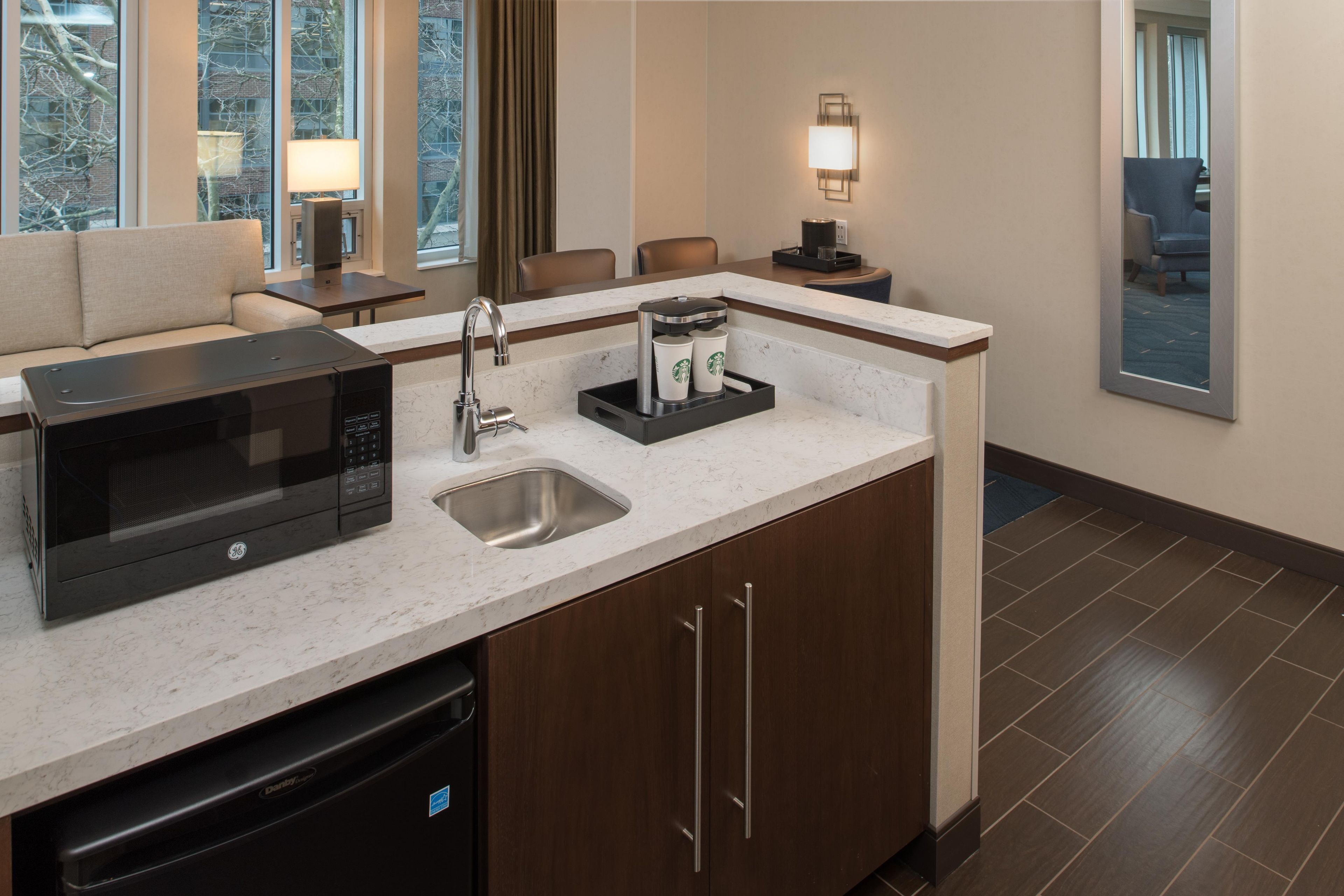 A compact kitchen with a built-in microwave, a sink, and a coffee maker.