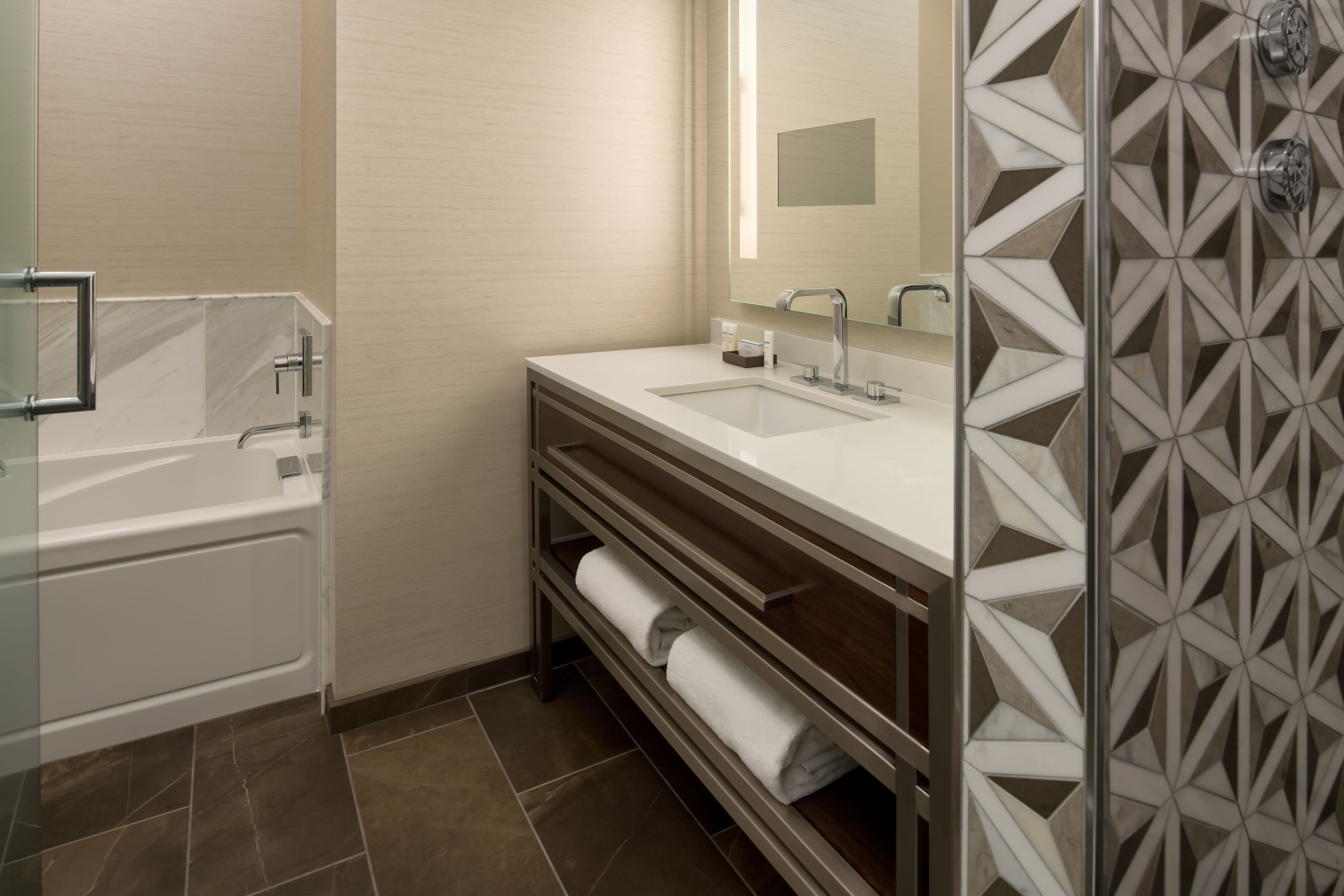 A modern bathroom with a bathtub, a sink, and a shower area.
