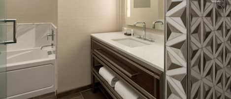 A modern bathroom with a bathtub, a sink, and a shower area.