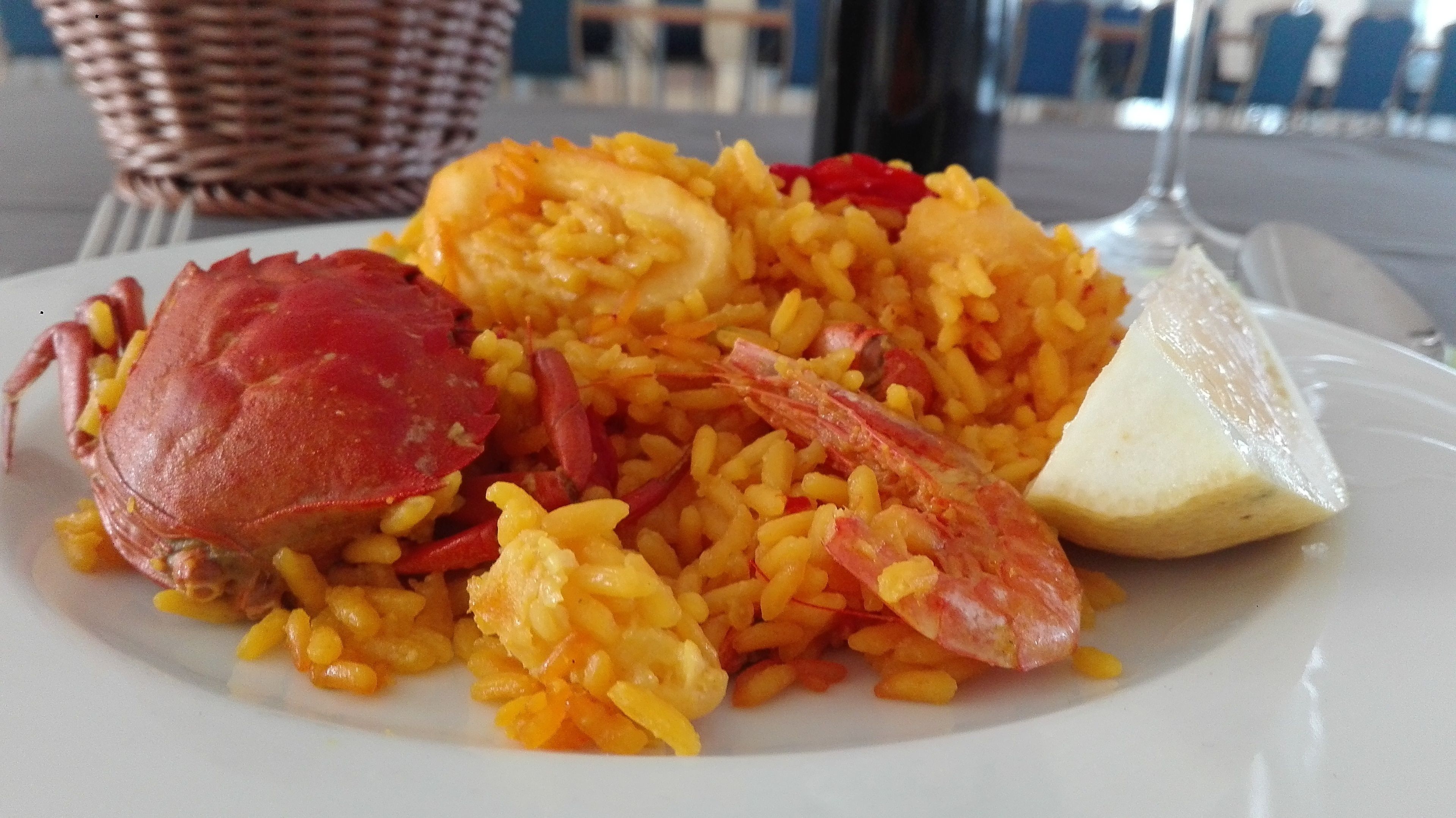 A plate of food with rice, shrimp, and a crab.
