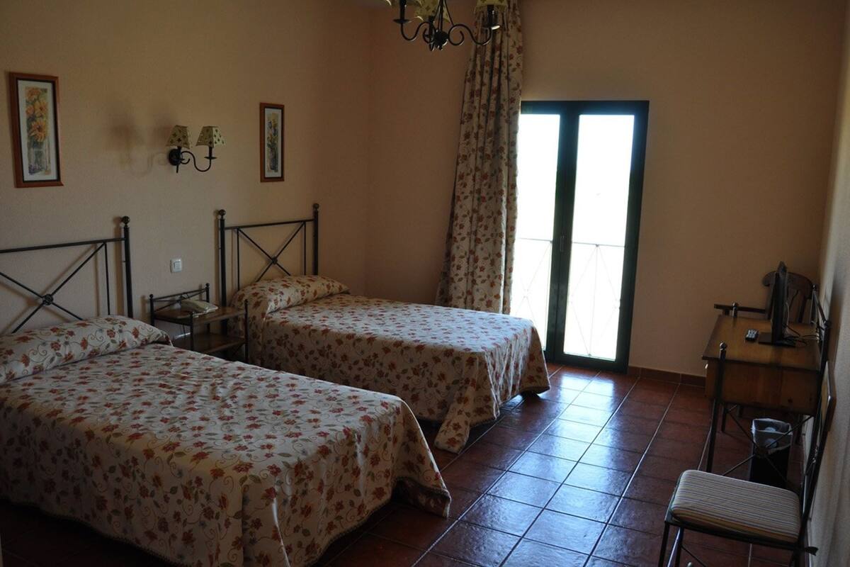 Ein Schlafzimmer mit zwei Betten, einem Schreibtisch und einem Stuhl.