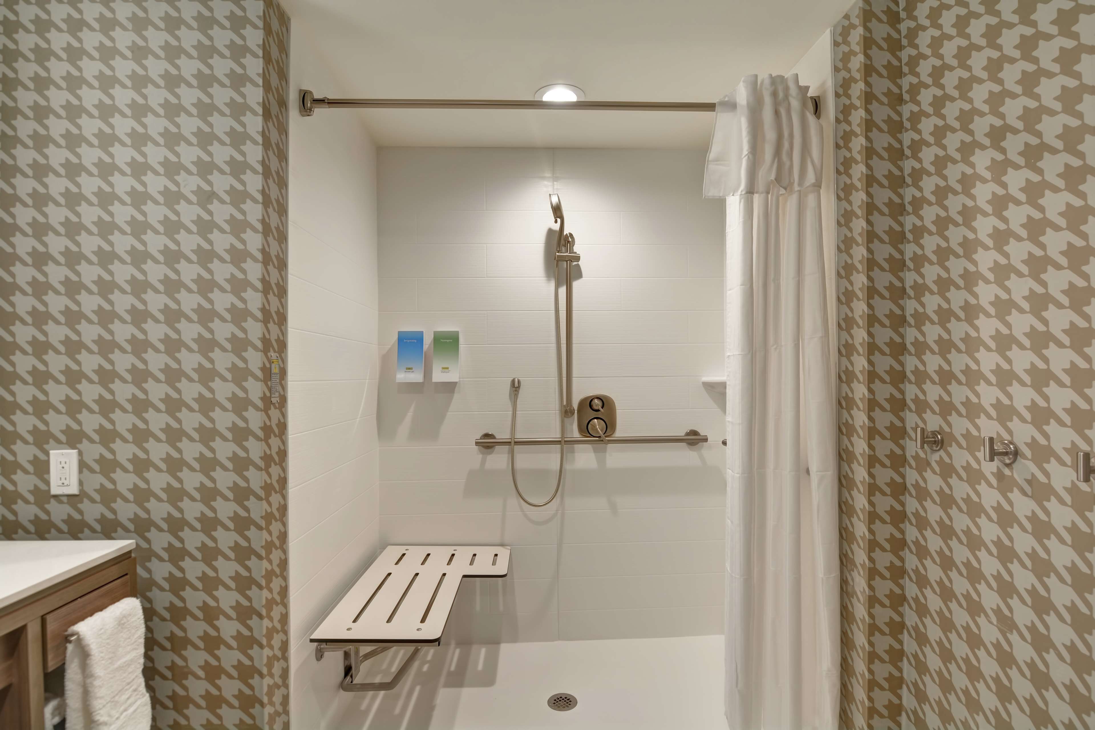 Une douche équipée d’un pommeau de douche à main et d’un panneau de commande.