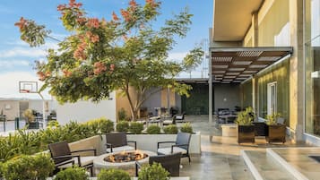 Un espacio al aire libre con patio amoblado, una chimenea y una canasta de baloncesto.