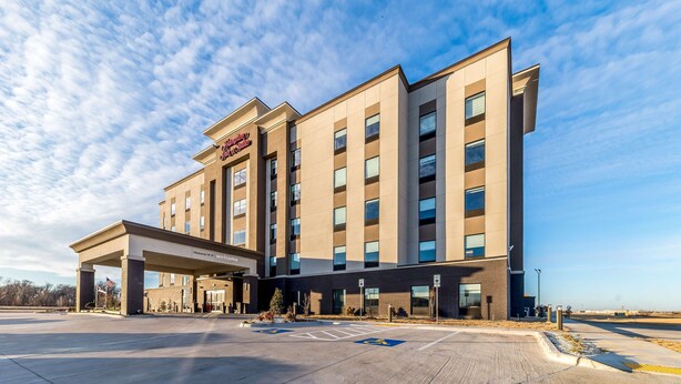 A modern hotel with a covered entrance and multiple floors.