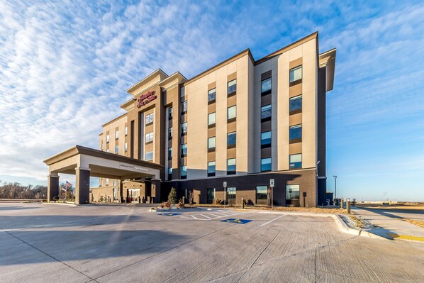 A modern hotel with a covered entrance and multiple floors.