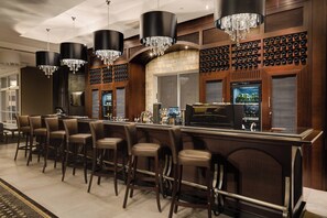 A bar area with a long counter, multiple bar stools, and a wine rack. - Protea Hotel Owerri Select (Owerri)
