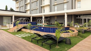 A modern hotel with a swimming pool, outdoor seating, and a well-maintained garden. - Protea Hotel Owerri Select (Owerri)
