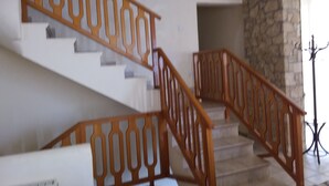 Una escalera con barandillas de madera y paredes de piedra.