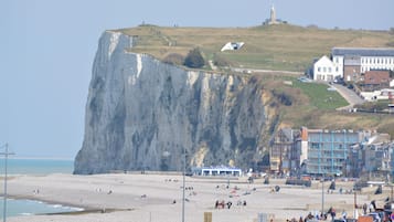 Une ville côtière caractérisée par une falaise imposante, une plage et des bâtiments.