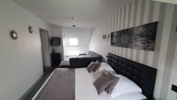 Relax in a stylish room with a large bed, flat-screen TV, and ceiling fan.