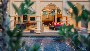 Uma área de piscina interior luxuosa, com espaço para sentar e um balcão de recepção.