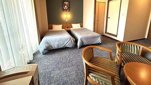 Quarto de hotel com duas camas, teto de madeira, uma mesa pequena e uma cadeira.