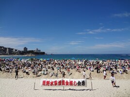 Una playa concurrida con gente tomando el sol y jugando.