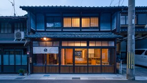 Un bâtiment traditionnel japonais, avec une façade en bois et de grandes fenêtres.