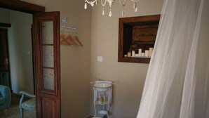 Une chambre à coucher comprenant un lit, une table de chevet, un luminaire suspendu, une fenêtre avec vue et une porte.