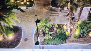An aerial view of a landscaped area with palm trees, a paved walkway, and decorative lights. - Apartment With Stunning Sea Views And Vision Of The Rock Of 🇬🇮Gibraltar (Estepona)