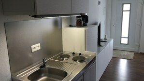 Una cocina moderna con electrodomésticos de acero inoxidable, un lavamanos empotrado y un ventanal que deja entrar luz natural.