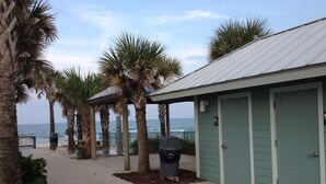 A beachfront building with a covered walkway, palm trees, and a view of the ocean. - Walk to Beach! Family Beach House, Game room!  Sunset View! (Daytona Beach)