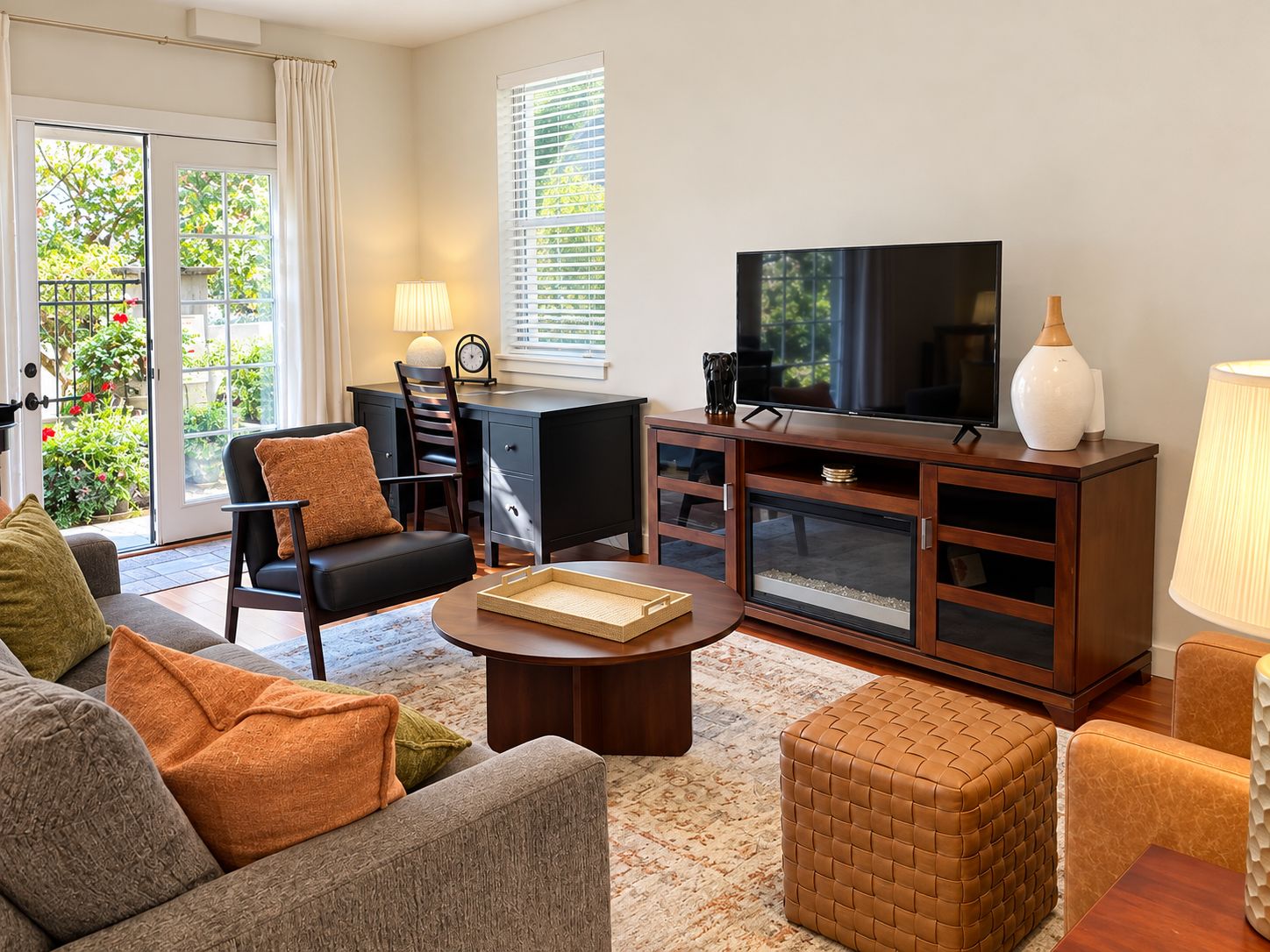 A living room with a sofa, armchair, coffee table, TV, and a cabinet.