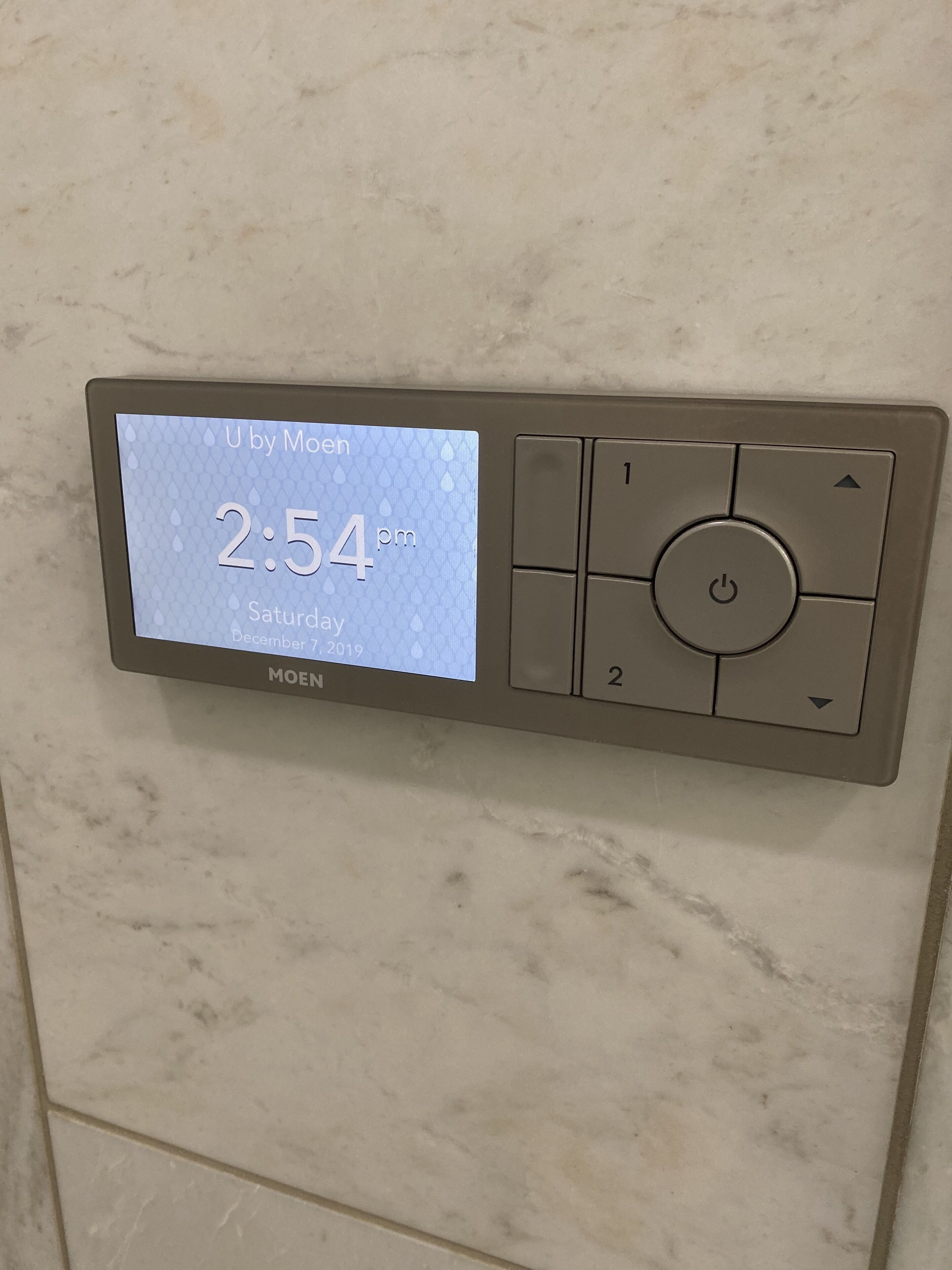 Een digitale thermostaat toont de tijd: 14:54 op zaterdag 7 december 2019.
