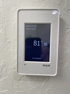 En termostat som visar en temperatur på 81°F, inställd på läget ”Enligt schema” den 7 december 2019, klockan 12.54.