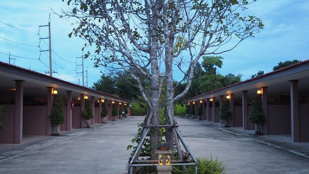 A row of motel rooms with a central tree and a lantern. - Rimmueng Resort (Phanom Sarakham)