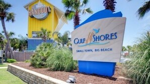 A sign for 'Culfs Shores' with a beach theme, including palm trees and a beach ball.