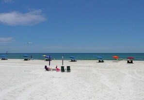 A beach with umbrellas and lounge chairs. - Pet Friendly!  2 bedroom/1.5 bath. Sleeps 6.  (Gulf Shores)