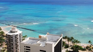 A high-rise hotel overlooking a beach with clear turquoise waters and a pier. - Ocean View Studio - Polu Hale - 2 min Walk from Beach (Honolulu)