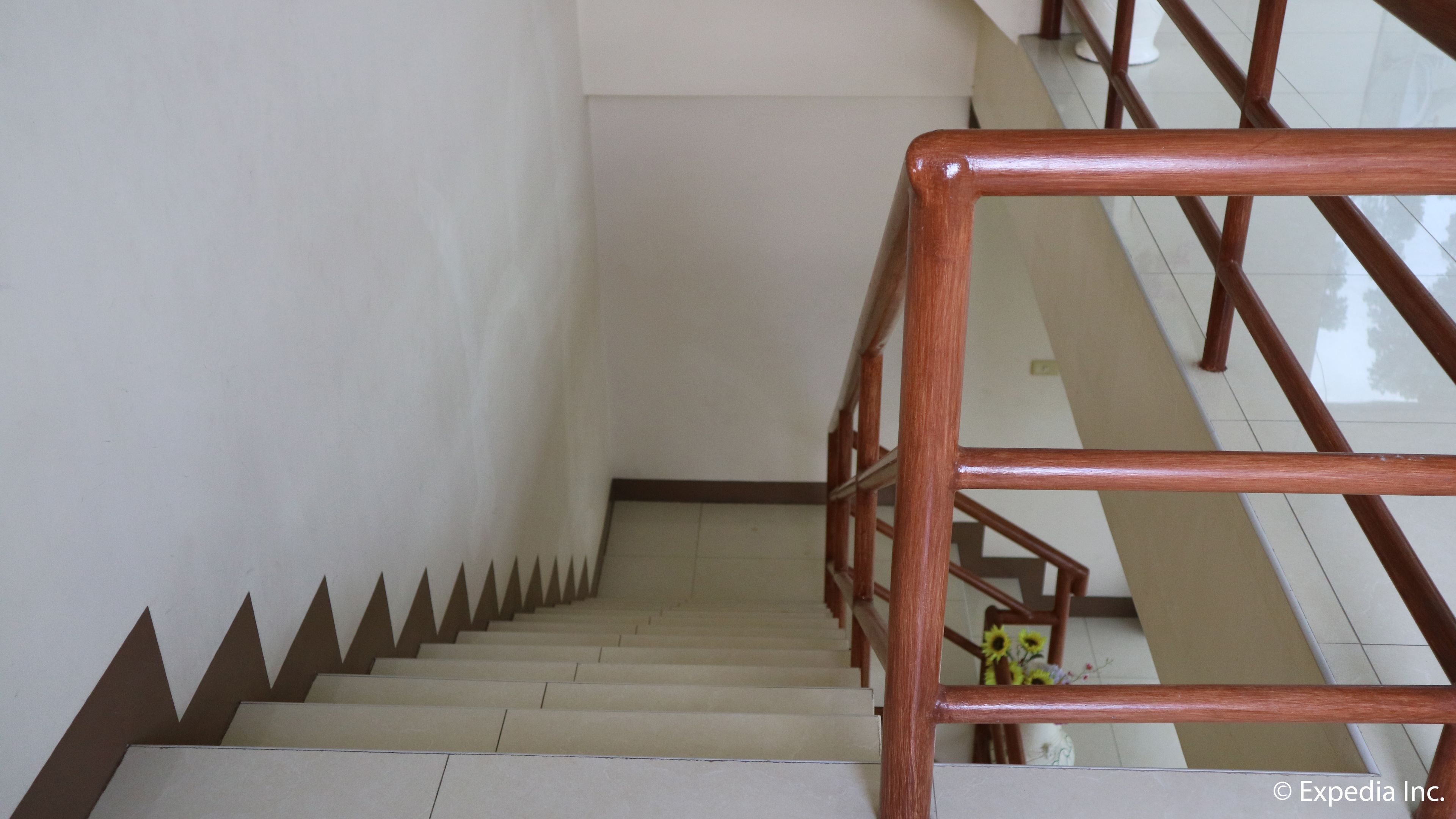 Un escalier avec une rampe en bois et un mur blanc.