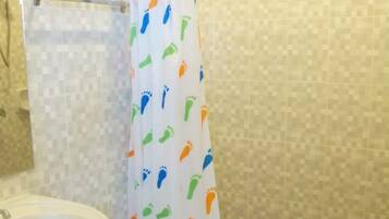 A bathroom with a toilet, sink, and shower curtain with a playful pattern.