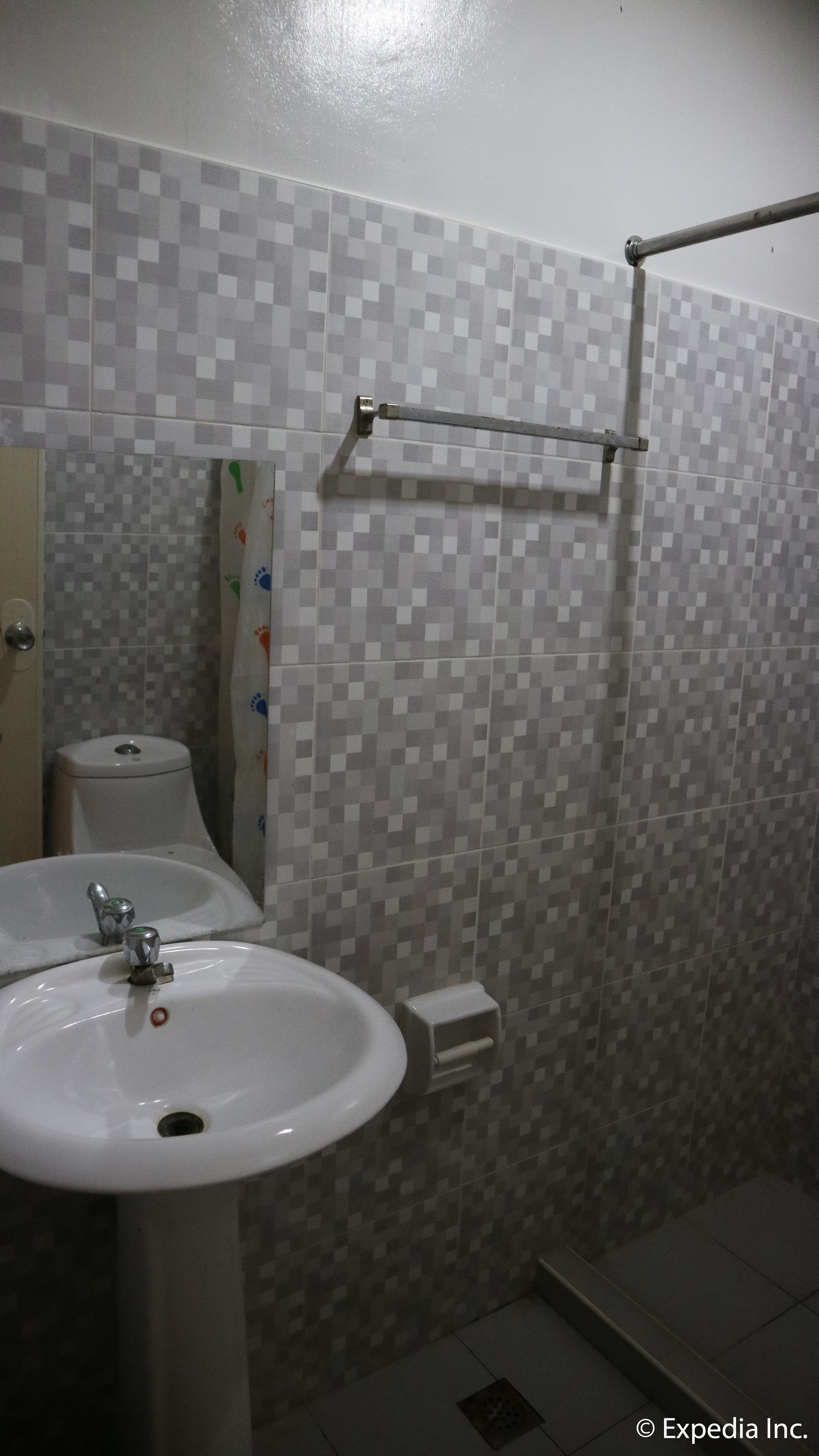 Un baño con lavamanos blanco, inodoro y zona de ducha.