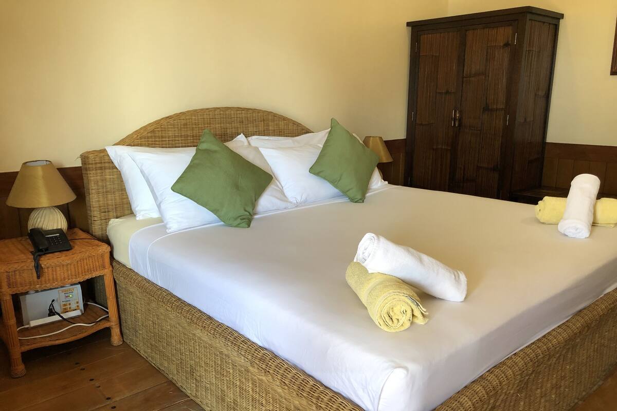Habitación Deluxe, frente a la playa | Minibar, caja fuerte, escritorio y ropa de cama