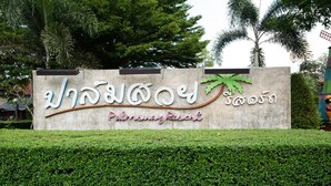 A sign for Palmsway Resort with a palm tree graphic and text in two languages. - Palmsuay Resort (Khao Saming)