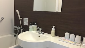 Ein modernes Badezimmer mit einem weißen Waschbecken, einem Spiegel und Pflegeprodukten auf der Ablagefläche.