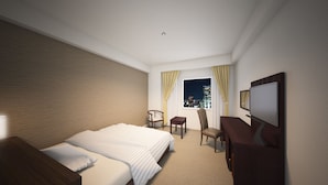 Ein Hotelzimmer mit Bett, Schreibtisch, Sessel, Fernseher und einem Fenster mit Vorhängen.